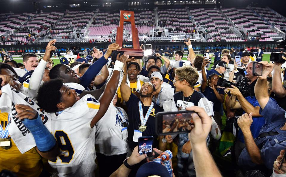 St. Thomas head coach Roger Harriott and his team celebrate winning the the Class 7A state championship 42-14 over Tampa Bay Tech at DRV PNK Stadium, Fort Lauderdale, FL  Dec. 17, 2021. 