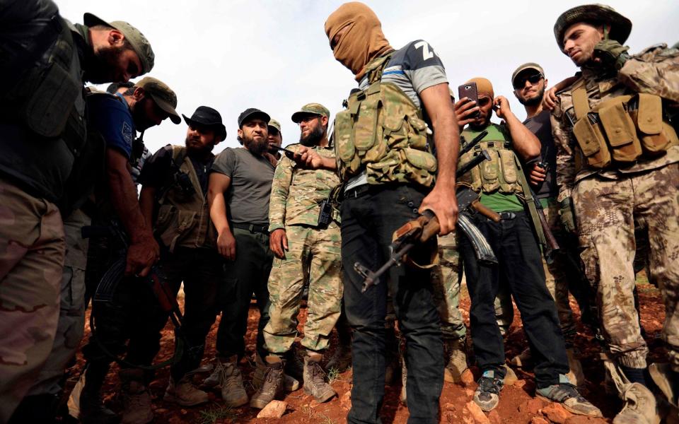 Syrian rebels gather in a field in the northern countryside of Hama province during clashes with regime forces - AFP