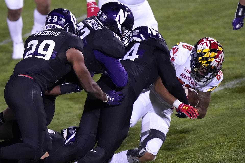 Maryland wide receiver DeJuan Ellis, right, is tackled by Northwestern defenders during the second half of an NCAA college football game in Evanston, Ill., Saturday, Oct. 24, 2020. (AP Photo/Nam Y. Huh)