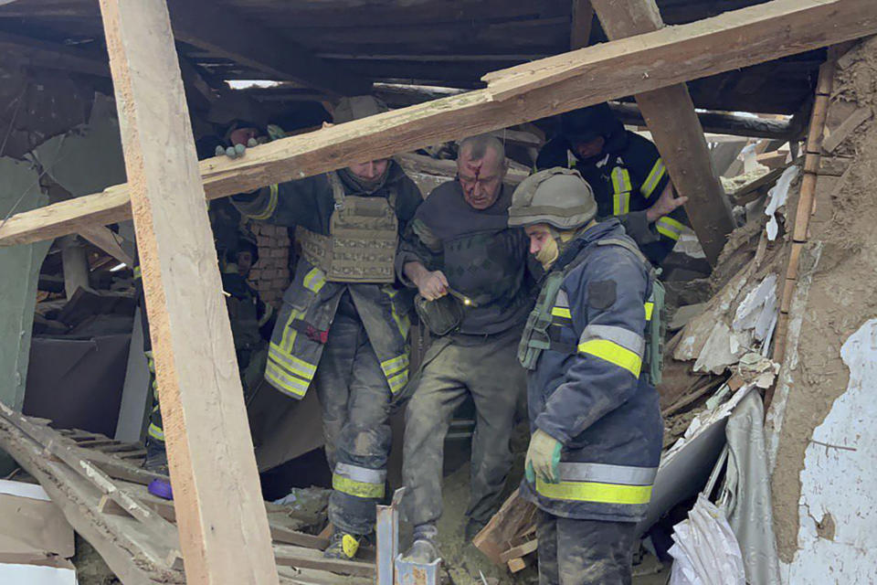 En esta imagen proporcionada por el Servicio Ucraniano de Emergencias, trabajadores de emergencias ayudan a un hombre herido después de que un ataque de misil ruso causara graves daños en edificio residenciales cerca de Krivói Rog, Ucrania, el lunes 8 de enero de 2024. (Servicio Ucraniano de Emegencias via AP)