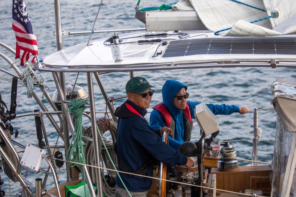 Two men stand on a yacht