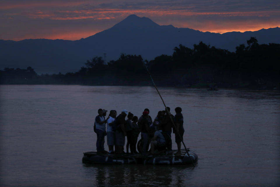 FILE - In this early Monday, June 10, 2019 file photo, Central American migrants stand on a raft to cross the Suchiate River from Guatemala to Mexico, with the Tacana volcano in the background, near Ciudad Hidalgo, Mexico. A record 71 million people were forcibly displaced around the world in 2018, according to a report last month by the United Nations refugee agency, in places as diverse as Turkey, Uganda, Bangladesh and Peru. (AP Photo/Marco Ugarte)
