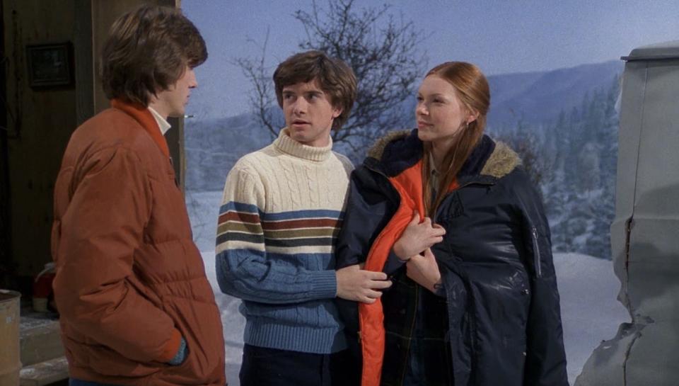 Eric and Donna smile smugly at Kelso outside of the ice shack, while Eric drapes his jacket over Donna's shoulders