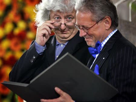 Hungarian writer Peter Esterhazy (L) jokes with his glasses as he receives the peace prize of the German bookseller association from chairman Dieter Schormann during a ceremony in Frankfurt's famous Paul's church, October 10, 2004. REUTERS/Kai Pfaffenbach