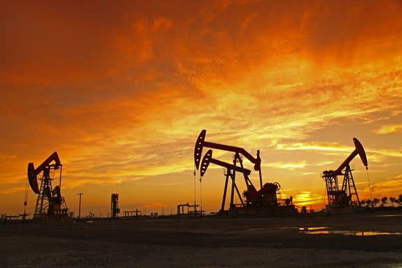 Oil pumps with a bright orange sky above.