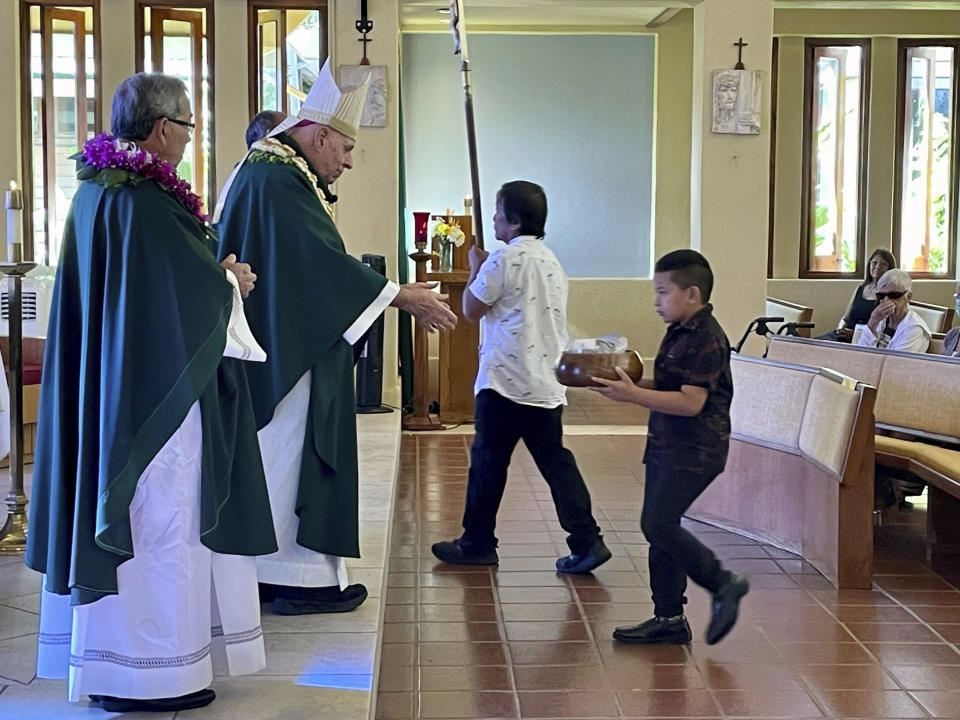 Most Rev. Clarence "Larry" Silva, the Bishop of Honolulu, presides over Mass at Sacred Hearts Mission Church in Kapalua, Hawaii, Sunday, Aug. 13, 2023. Sacred Hearts Mission Church hosted congregants from Maria Lanakila Catholic Church in Lahaina, including several people who lost family members in fires that burned most of the Maui town days earlier. (AP Photo/Haven Daley)