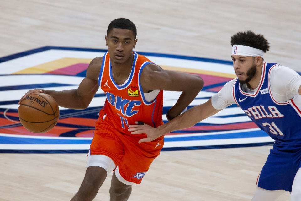 Oklahoma City Thunder guard Theo Maledon (11) goes against Philadelphia 76ers guard Seth Curry (31) during the first half of an NBA basketball game, Saturday, April 10, 2021, in Oklahoma City. (AP Photo/Garett Fisbeck)