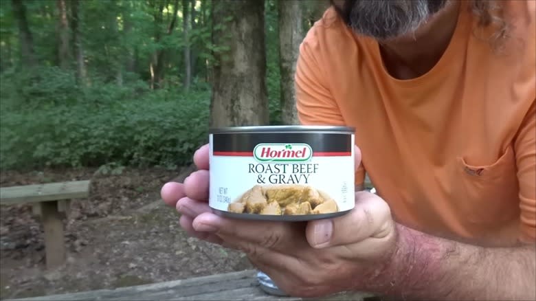 Person holding Hormel canned beef