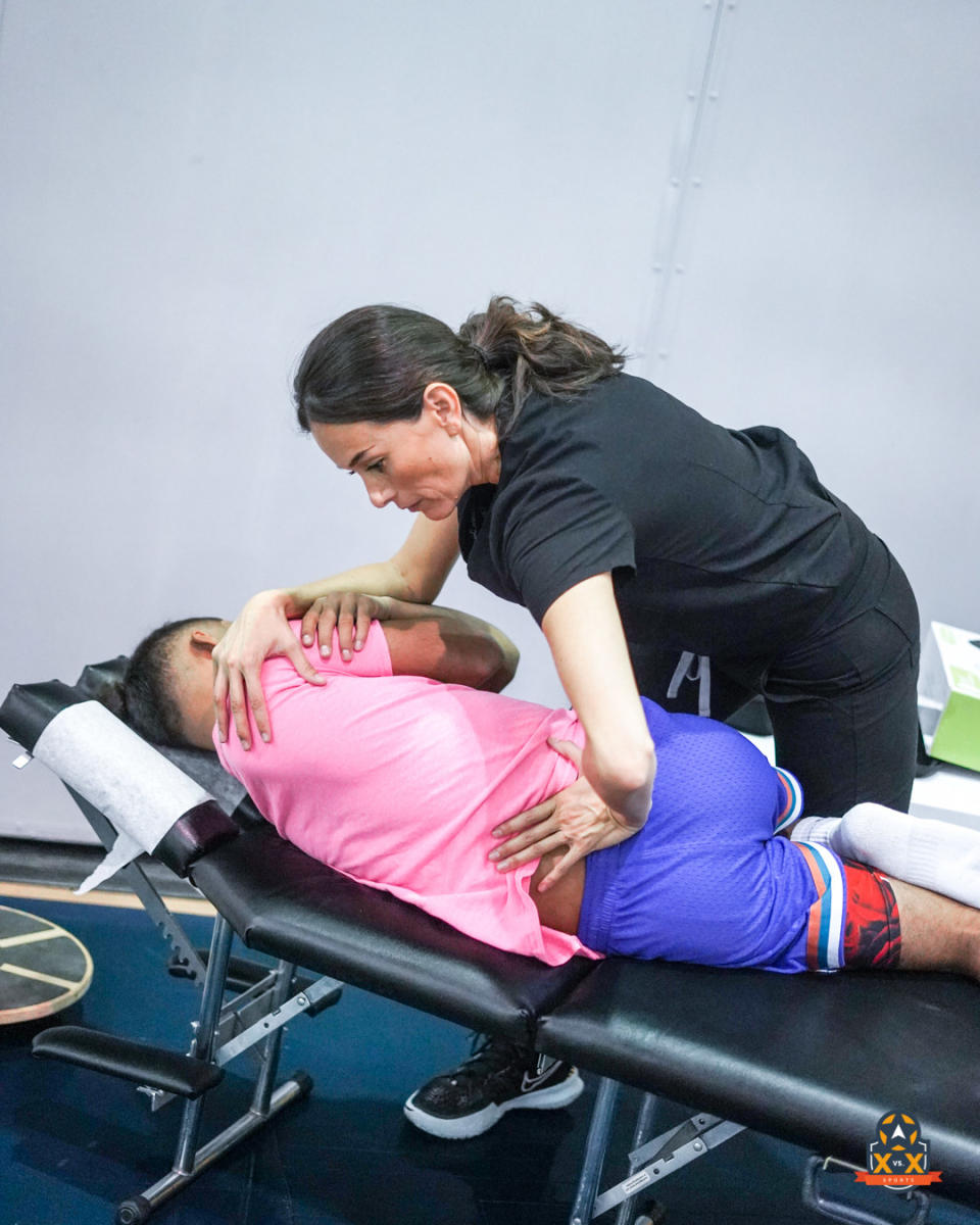 Dr. Cherene Toscano performs chiropractic treatment on an XvsX Sports basketball player.