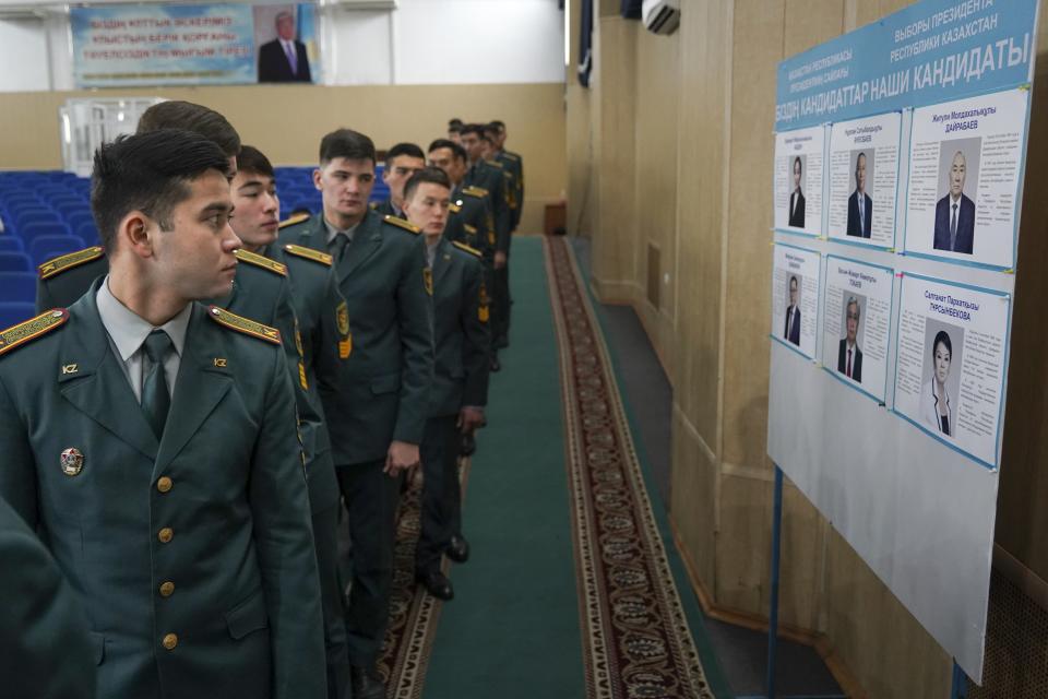 National servicemen lineup to cast their votes next to a poster showing presidential candidates at a polling station in Almaty, Kazakhstan, Sunday, Nov. 20, 2022. Kazakhstan's president appears certain to win a new term against little-known challengers in a snap election on Sunday. Five candidates are on the ballot against President Kassym-Jomart Tokayev, who faced a bloody outburst of unrest early this year and then moved to marginalize some of the Central Asian country's longtime powerful figures. (Vladimir Tretyakov/NUR.KZ via AP)