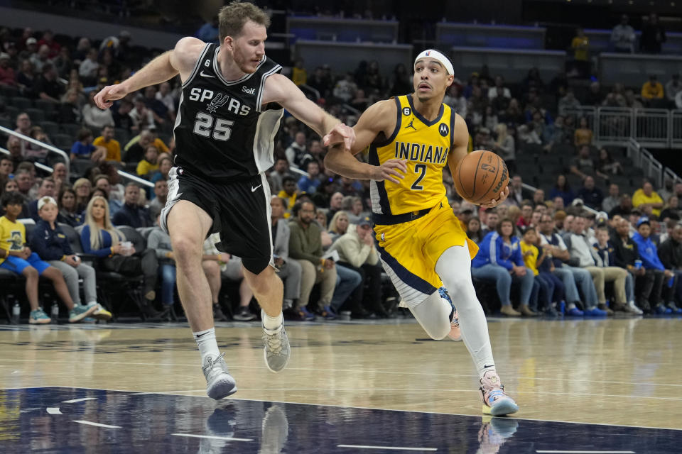 Indiana Pacers guard Andrew Nembhard (2) drives around San Antonio Spurs center Jakob Poeltl (25) during the second half of an NBA basketball game in Indianapolis, Friday, Oct. 21, 2022. (AP Photo/AJ Mast)