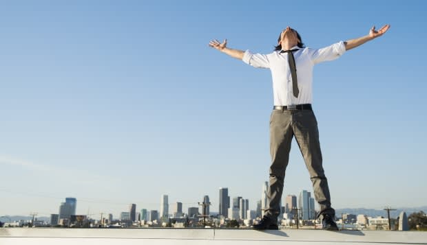 Mixed race businessman standing on urban rooftop