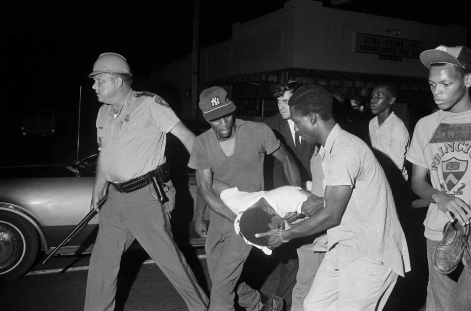 Benjamin Brown being carried away after he was shot by the police in Jackson, Mississippi, in May 1967. At left, Lloyd Jones, a state trooper who would later be implicated in the shooting, leads the group down a street.