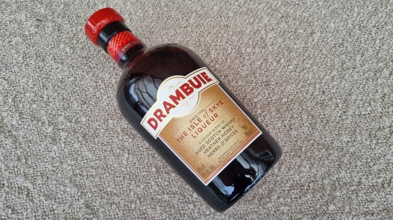 Tilted bottle of Drambuie on carpet