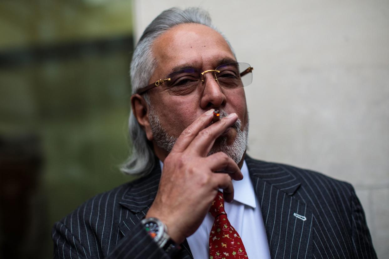 Indian businessman Vijay Mallya smokes during a break in his extradition ruling at Westminster Magistrates Court on December 10, 2018 in London, England.