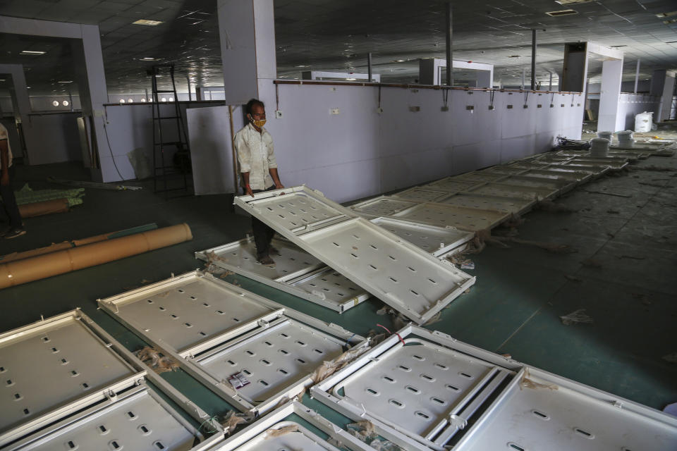 An Indian laborer works during the setting up of a temporary 500 bedded COVID-19 hospital by the Defence Research and Development Organization in Jammu, India, Monday, May 24, 2021. India crossed another grim milestone Monday of more than 300,000 people lost to the coronavirus as a devastating surge of infections appeared to be easing in big cities but was swamping the poorer countryside. (AP Photo/Channi Anand)