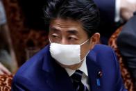 FILE PHOTO: Japan's Prime Minister Shinzo Abe wears a protective face mask as he attends an upper house parliamentary session
