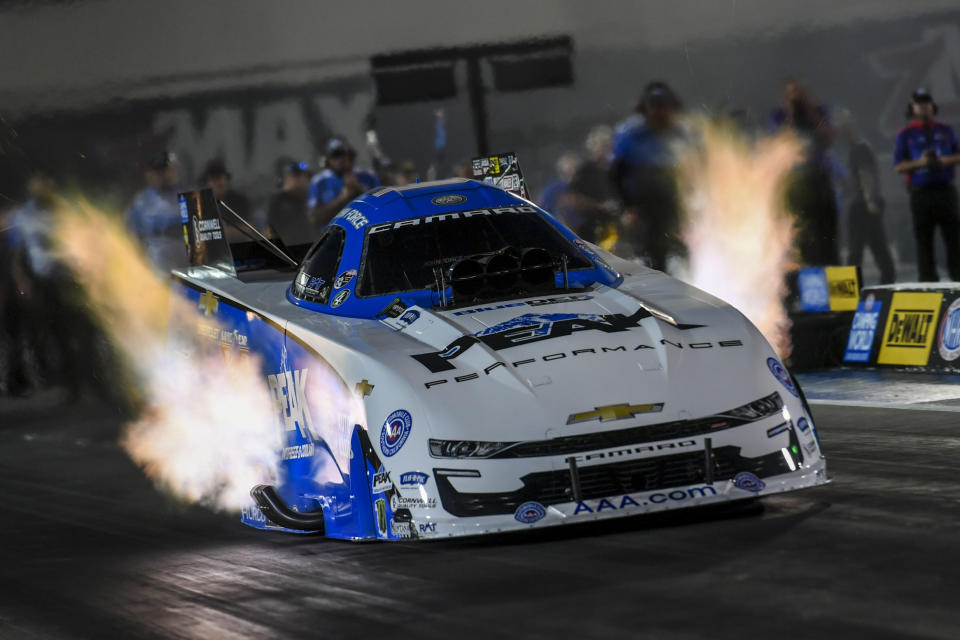 In this photo provided by the NHRA, Funny Car points leader John Force races to the provisional No. 1 position in his first-round qualifying run in his PEAK Chevrolet Camaro SS at the DeWalt NHRA Carolina Nationals at zMAX Dragway in Concord, N.C., Friday, Sept. 17, 2021 (Richard H. Shute/NHRA via AP)