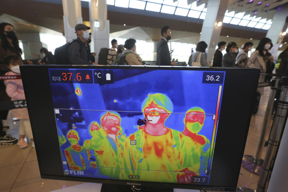 A thermal camera monitor shows the body temperature of passengers as they wait in line before boarding airplanes at the domestic flight terminal of Gimpo airport in Seoul, South Korea, Wednesday, April 29, 2020. South Korean officials have issued public pleas for vigilance to maintain hard-won gains against the coronavirus as the nation enters its longest holiday since infections surged in February. (AP Photo/Ahn Young-joon)