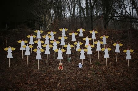 Twenty-seven wooden angel figures are seen placed in a wooded area beside a road near the Sandy Hook Elementary School for the victims of a school shooting in Newtown, Connecticut December 16, 2012. REUTERS/Mike Segar