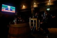 People watch Britain's Prime Minister Boris Johnson making a speech, at a pub, amid the outbreak of the coronavirus disease (COVID-19) in Liverpool