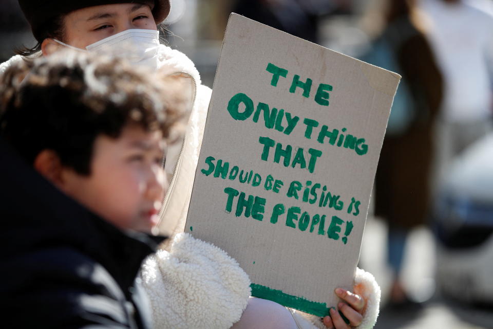 A person holds a sign during a protest about the rising cost of living during a demonstration in London