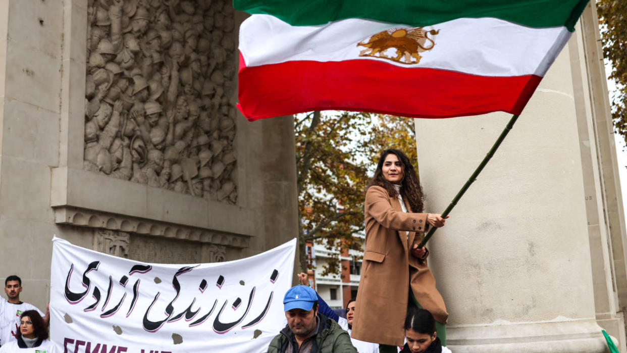 A protestor waves the Iranian flag during a rally in support of the demonstrations in Iran, in Toulouse, south-western France, on December 3, 2022. - More than 200 people have been killed in Iran since nationwide protests erupted over the death in police custody of Mahsa Amini, the country's top security body said on December 3, 2022. (Photo by Charly TRIBALLEAU / AFP)