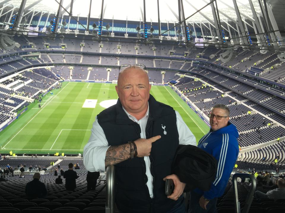 In this April 13, 2019, photo, Dave French, a 55-year-old Tottenham supporter, stands at Tottenham Hotspur Stadium before the team's Premier League match against Huddersfield in London. French was a supervisor at Tottenham's old stadium, White Hart Lane. "I'm not sure you can replace White Hart Lane, because that was a ground that we all grew up with and we all loved. I've got lots and lots of memories at White Hart Lane. But things move on, country moves on, clubs have got to move on, as well," French said. "In the old ground, we had food and drink but there was just never enough. And it was never quick enough." (AP Photo/Ron Blum)