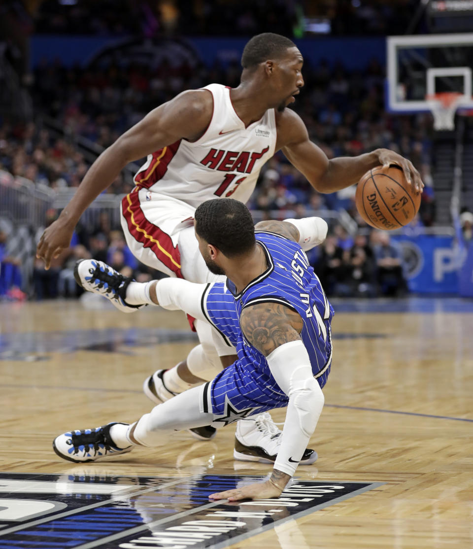 Orlando Magic's D.J. Augustin, right, tumbles backward as he collides with Miami Heat's Bam Adebayo during the first half of an NBA basketball game, Sunday, Dec. 23, 2018, in Orlando, Fla. (AP Photo/John Raoux)