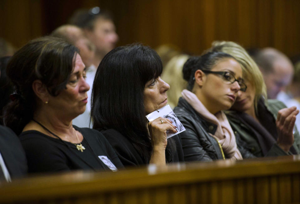 A family friend of the late Reeva Steenkamp holds a portrait of Steenkamp as she attends the trial of Oscar Pistorius during his trial in court in Pretoria, South Africa, Thursday, March 13, 2014. Pistorius is charged with the shooting death of girlfriend Steenkamp, on Valentines Day in 2013. (AP Photo/Alet Pretorius, Pool)