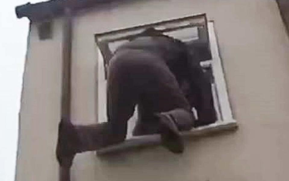 Pictured: Burglar has to be rescued after getting stuck in bathroom window as he tries to climb into woman's house