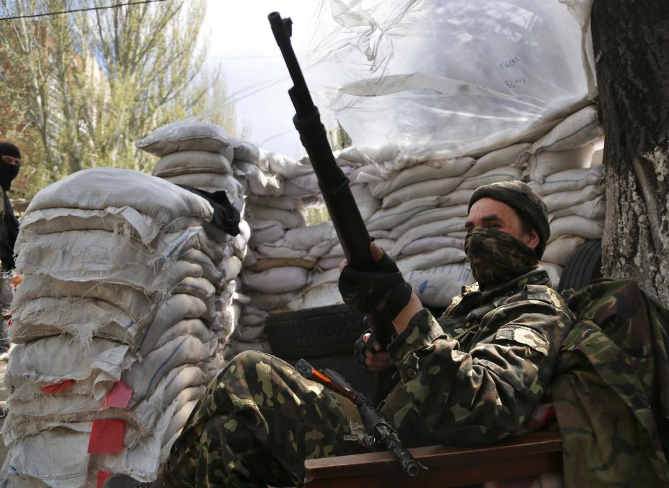 A pro-Russian masked gunman mans his post on a street in the center of Slovyansk, eastern Ukraine, Wednesday, April 23, 2014. Pro-Russian gunmen in eastern Ukraine admitted on Wednesday that they are holding American journalist Simon Ostrovsky, saying he was suspected of unspecified "bad activities." (AP Photo/Sergei Grits)