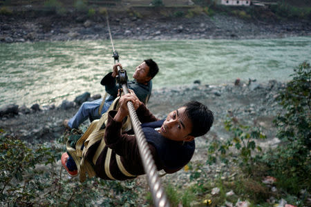 Villagers are seen crossing the river with a zipline in Lazimi village in Nujiang Lisu Autonomous Prefecture in Yunnan province, China, March 28, 2018. Picture taken March 28, 2018. REUTERS/Aly Song
