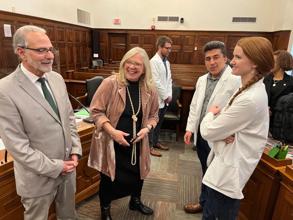 Northeast Ohio Medical University students Emily Huff, from right, and Michael Massey talk with Akron City Council members Nancy Holland and Jeff Fusco after council approved a resolution on March 13 urging the mayor to fund a medical debt relief plan, which the students brought to Holland.