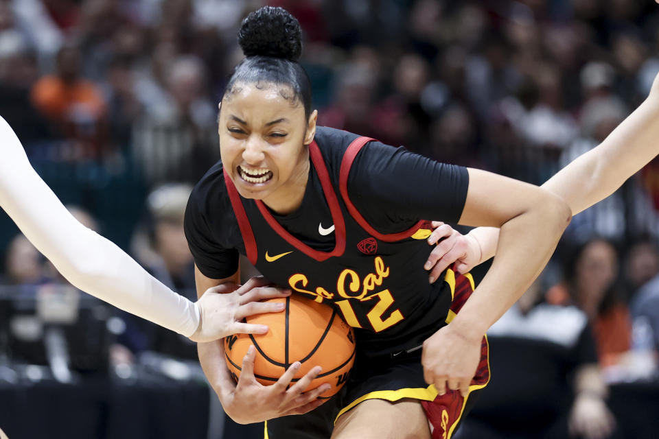 Southern California guard JuJu Watkins (12) reacts while driving past a pair of Stanford defenders during the first half of an NCAA college basketball game in the championship of the Pac-12 tournament, Sunday, March 10, 2024, in Las Vegas. (AP Photo/Ian Maule)