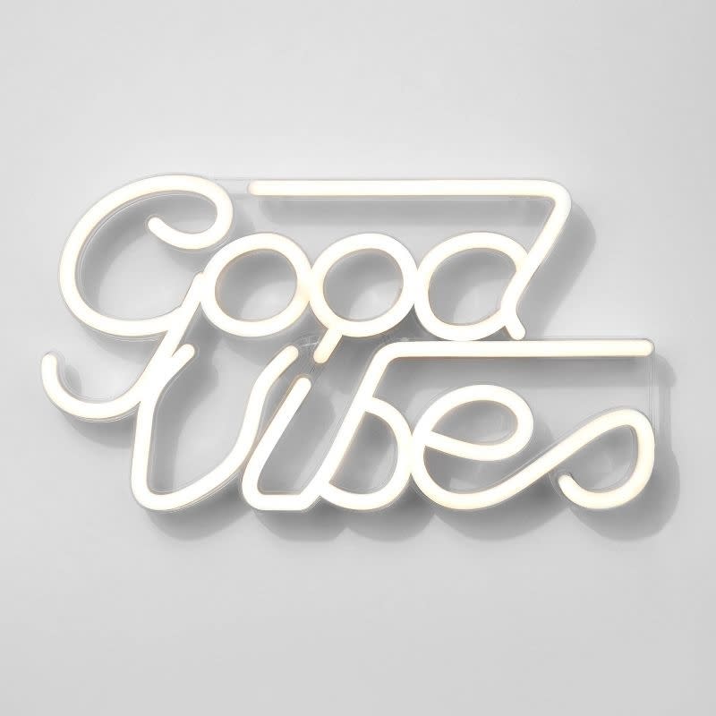 Neon sign on a wall reading 'Good Vibes' in cursive script, used for home decor inspiration