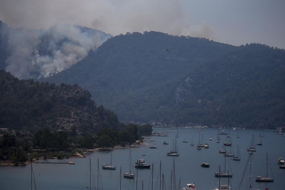 A wildfire burns the forest in Turgut village, near tourist resort of Marmaris, Mugla, Turkey, Wednesday, Aug. 4, 2021. As Turkish fire crews pressed ahead Tuesday with their weeklong battle against blazes tearing through forests and villages on the country's southern coast, President Recep Tayyip Erdogan's government faced increased criticism over its apparent poor response and inadequate preparedness for large-scale wildfires.(AP Photo/Emre Tazegul)