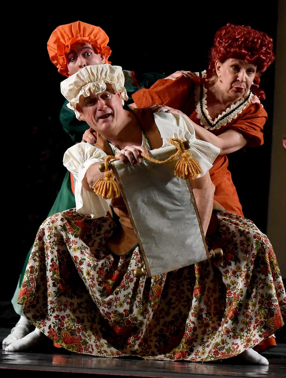 In the production of "Cinderella," stepsister Jeff Boze of Holland, Ohio, (foreground), stepmother Mary Barnas of Monroe and stepsister Josh Mohler of Monroe run through a scene reading the announcement for the ball as the River Raisin Ballet Company presents "Cinderella" at the River Raisin for the Arts.