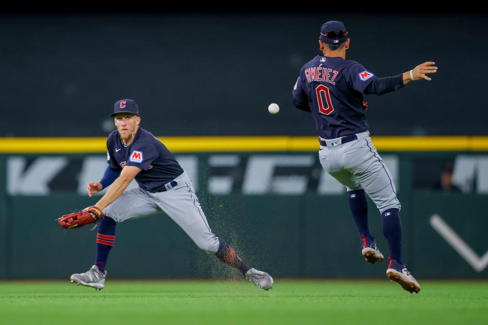 Cleveland Guardians' Myles Straw, left, and Andres Gimenez, right, react after a fly ball dropped for a single during the third inning of a baseball game against the Texas Rangers, Sunday, July 16, 2023, in Arlington, Texas. (AP Photo/Gareth Patterson)