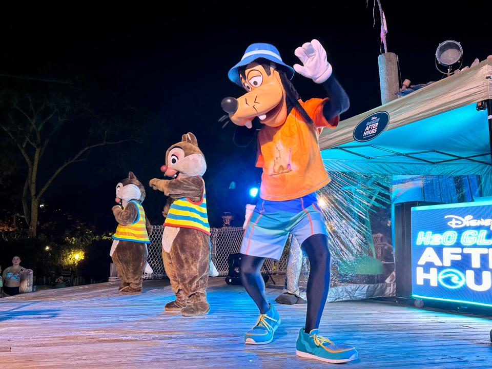 goofy and chip an dale characters on a stage dancing