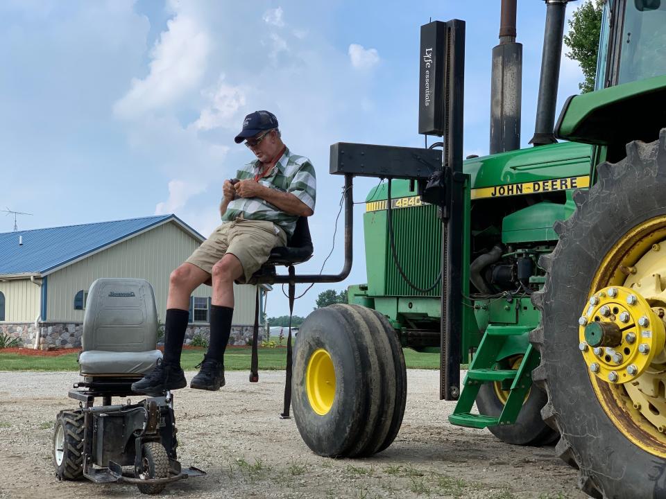 In this July 10, 2019, photo, farmer Mark Hosier, 58, uses a lift to get into a tractor on his farm in Alexandria, Ind. Hosier was injured in 2006, when a 2000-pound bale of hay fell on him while he was working. Assistive technology, help from seasonal hires and family members, and a general improvement in the health of U.S. seniors in recent decades have helped farmers remain productive and stay on the job well into their 60s, 70s and beyond. (Andrew Soregel via AP)