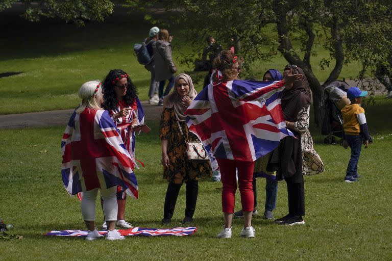 La gente viste banderas de la Unión en St James's Park, antes del inicio del fin de semana del Jubileo de la Reina, en Londres, el miércoles 1 de junio de 2022. Gran Bretaña celebrará los 70 años de la reina Isabel II en el trono con cuatro días de festividades que comienzan con su cumpleaños ceremonial desfile el 2 de junio de 2022. (AP Photo/Alberto Pezzali)