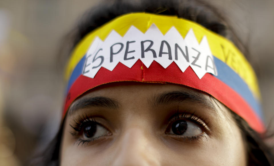 A Venezuelan, anti-government protester wears a headband with the colors of the Venezuelan flag and the Spanish word "Hope" during a demonstration in Buenos Aires, Argentina, Wednesday, Jan. 23, 2019. Hundreds of people, mostly Venezuelan migrants, held a rally against Venezuelan President Nicolas Maduro and in favor of Juan Guaido, head of Venezuela's opposition-run congress who today proclaimed himself president of the South American nation. (AP Photo/Natacha Pisarenko)