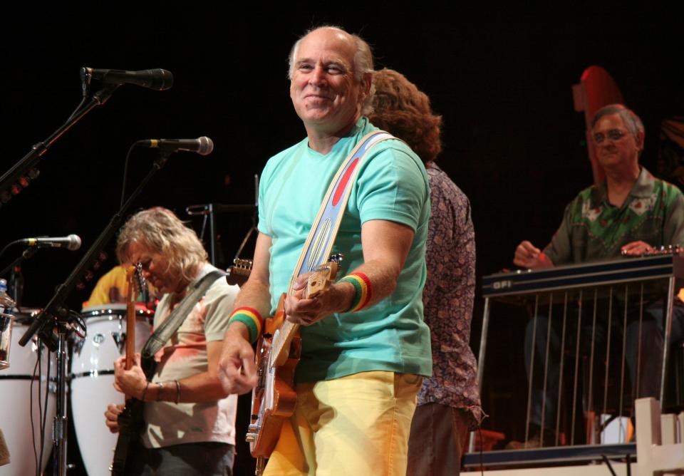 Jimmy Buffett playing the guitar on stage