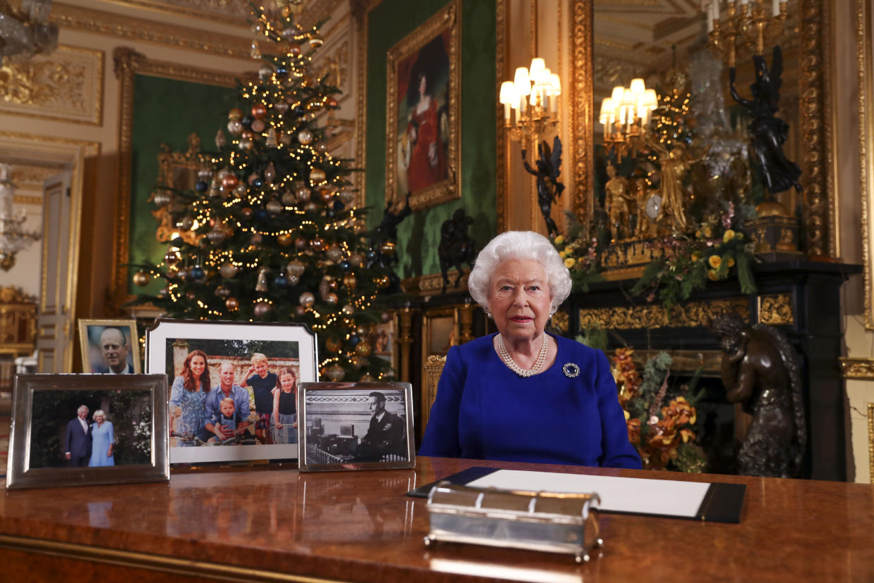The Queen recording her annual Christmas broadcast in Windsor Castle surrounded by pictures of her family. (PA)