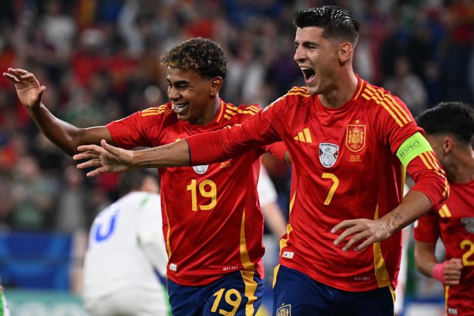 Spain's Lamine Yamal (19) and Alvaro Morata celebrate after Italy's Riccardo Calafiori scored an own goal.