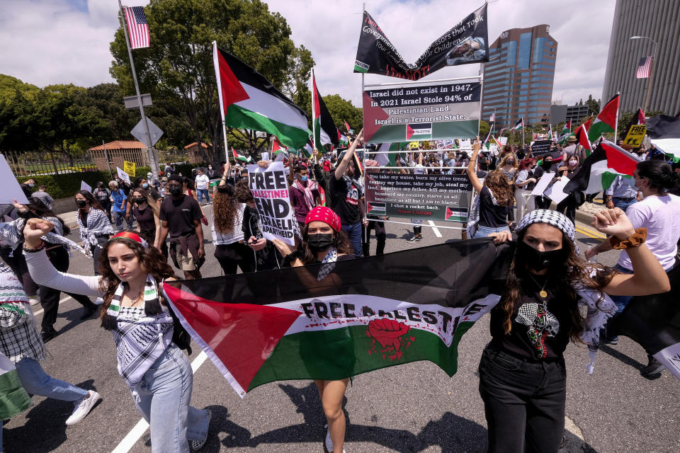 Demonstrators holding signs march to the Israeli Consulate during a protest against Israel and in support of Palestinians during the conflict in the Middle East, Saturday, May 15, 2021, in the Westwood section of Los Angeles. (AP Photo/Ringo H.W. Chiu)