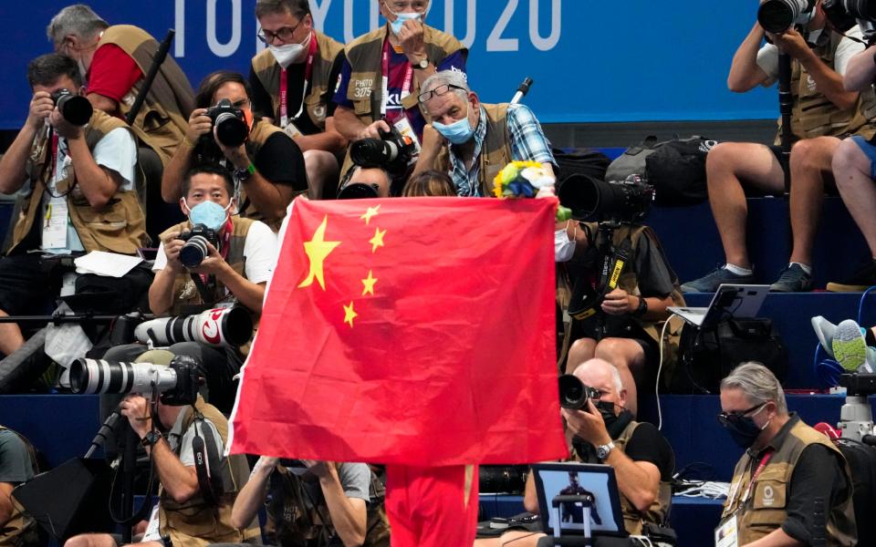 A Chinese flag is unfurled on the podium of a swimming event final at the 2020 Summer Olympics, on July 29, 2021, in Tokyo, Japan