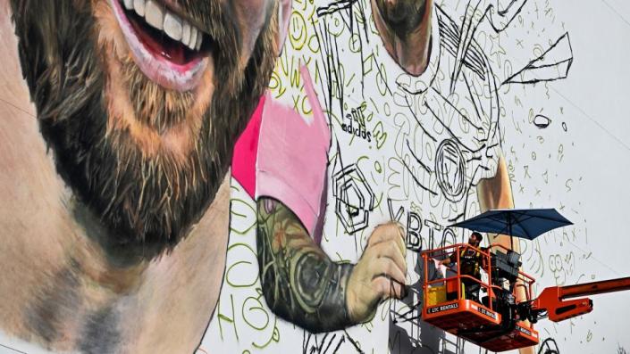 David Beckham helped Argentine artist Maximiliano Bagnasco (pictured) paint a giant mural of Messi. - Chandan Khanna/AFP/Getty Images