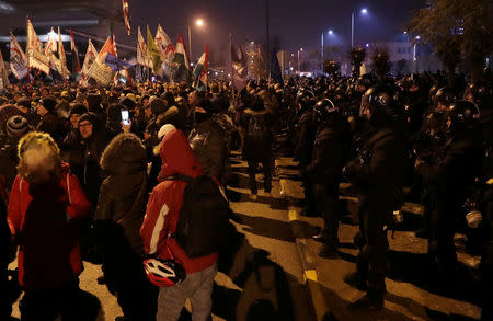 Demonstrators and police are seen during a protest against a proposed new labor law, billed as the "slave law", outside the headquarters of the Hungarian state television in Budapest, Hungary, December 17, 2018. REUTERS/Marko Djurica